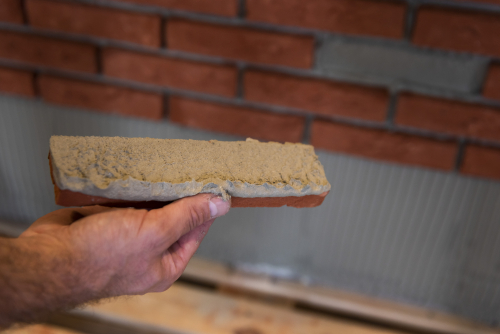 Controleer de verlijming van de steenstrip door steekproefsgewijs een steenstrip los te halen.